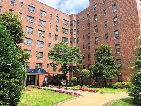 a large brick building with a sidewalk in front of it
